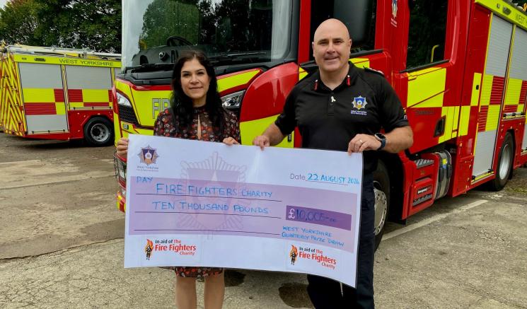 £10,000 cheque presented to Sherine Wheeler of The Fire Fighters Charity by CFO, John Roberts