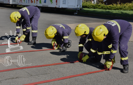 4 young adults in youth fire kit rolling hoses