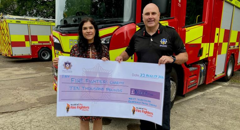 £10,000 cheque presented to Sherine Wheeler of The Fire Fighters Charity by CFO, John Roberts