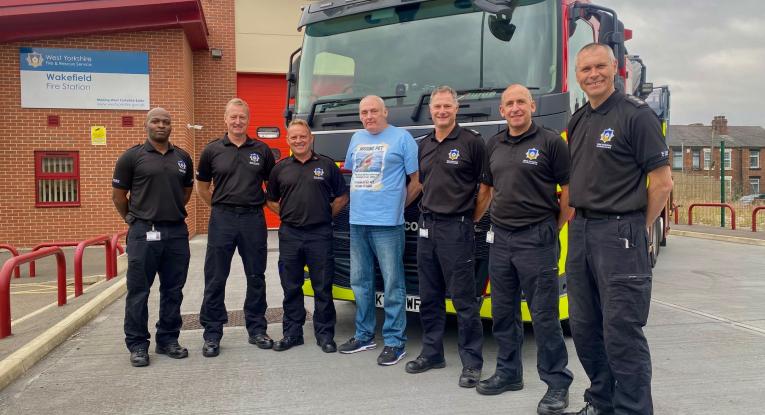 Wakefield Green Watch and Mr Whittaker standing in front of a fire aerial ladder platform